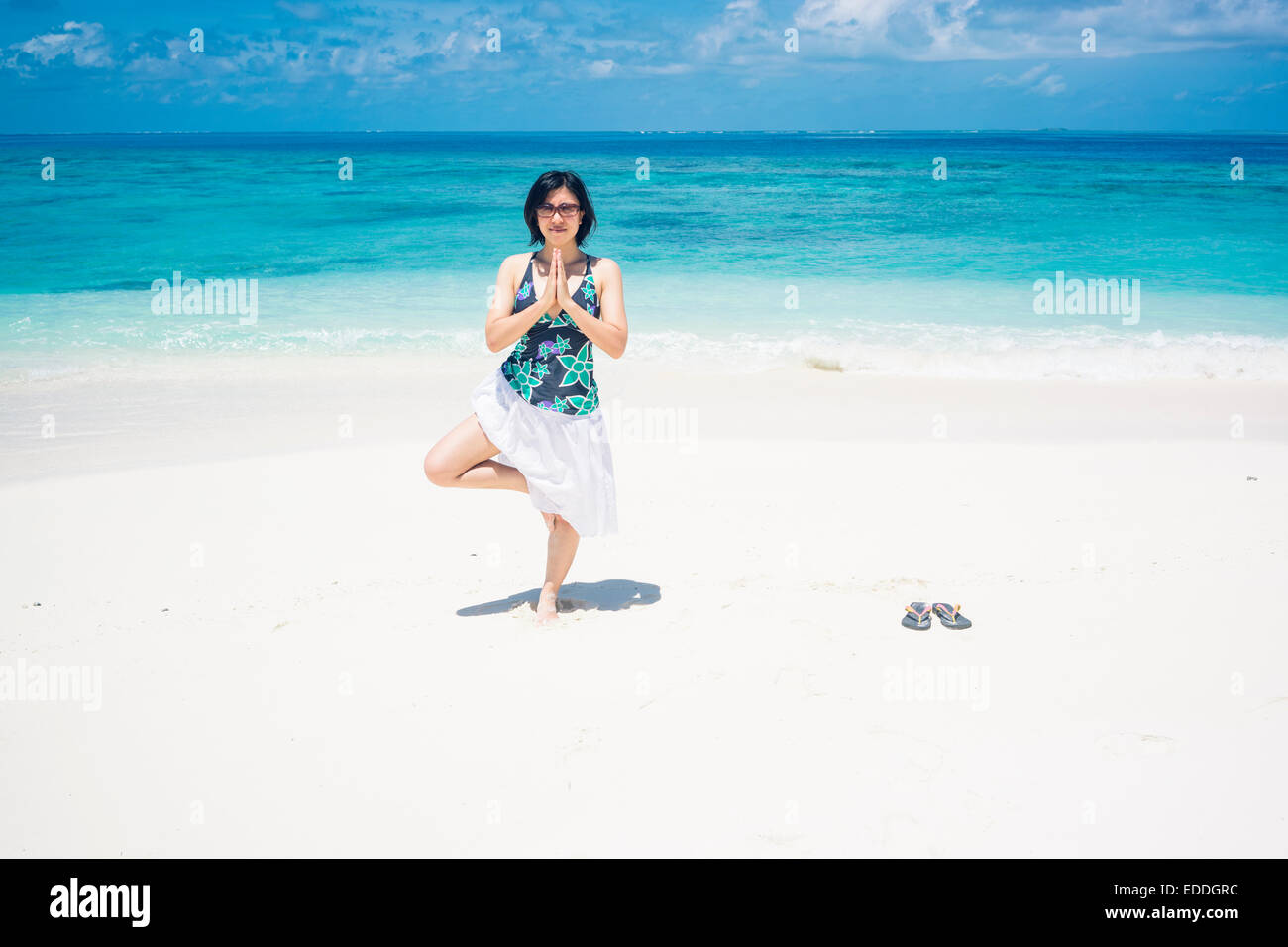 Les Maldives, Ari Atoll, young woman doing yoga exercice sur la plage Banque D'Images