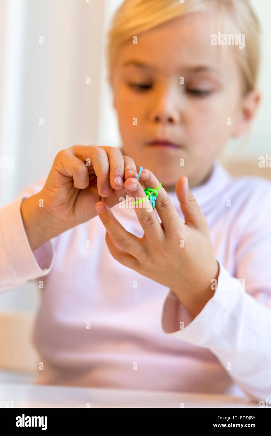 Petite fille faire loomboard avec bracelets Banque D'Images