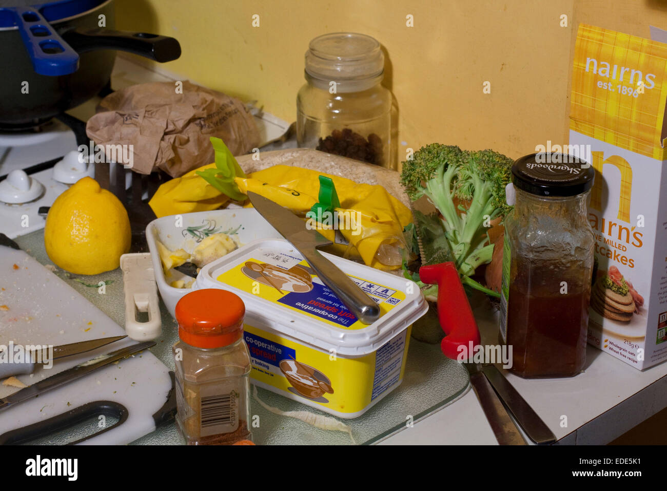 Une pile malpropre de l'alimentation et de couteaux sur une surface de travail de cuisine Banque D'Images