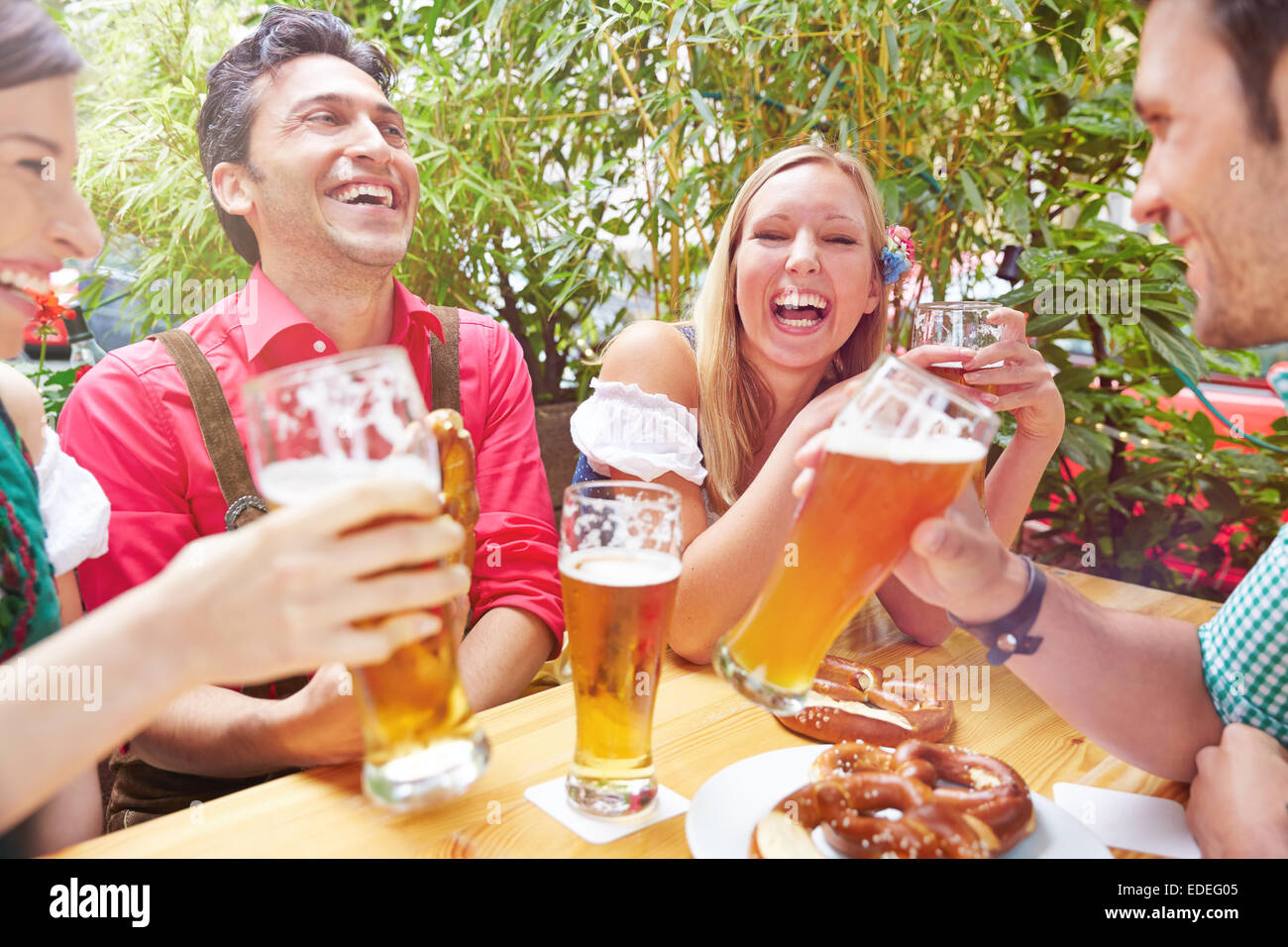Happy friends laughing in beer jardin en été en Bavière Banque D'Images