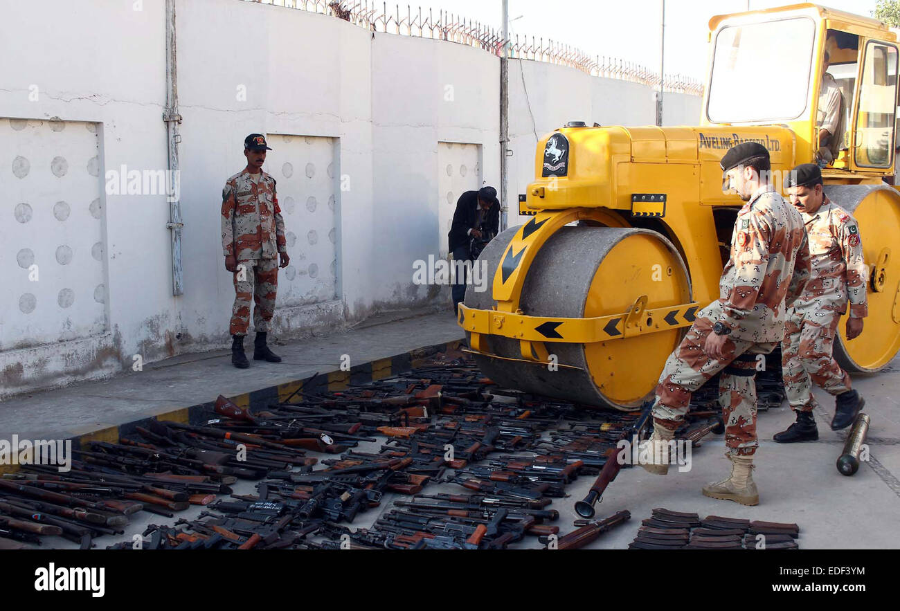 Rouleau de bulldozer lourd détruisant les armes saisies recouvrés au cours de raids dans différentes parties de Karachi à l'aile 93 Rangers du Sind à Karachi le Mardi, Janvier 06, 2015. Rangers du Sind a détruit un grand nombre d'armes saisies et l'énorme quantité de bouteilles de liqueur alcoolique dans la perception du terrorisme et de la criminalité campagne de cessation pour maintenir la paix, la loi et l'ordre dans la région métropolitaine. Banque D'Images