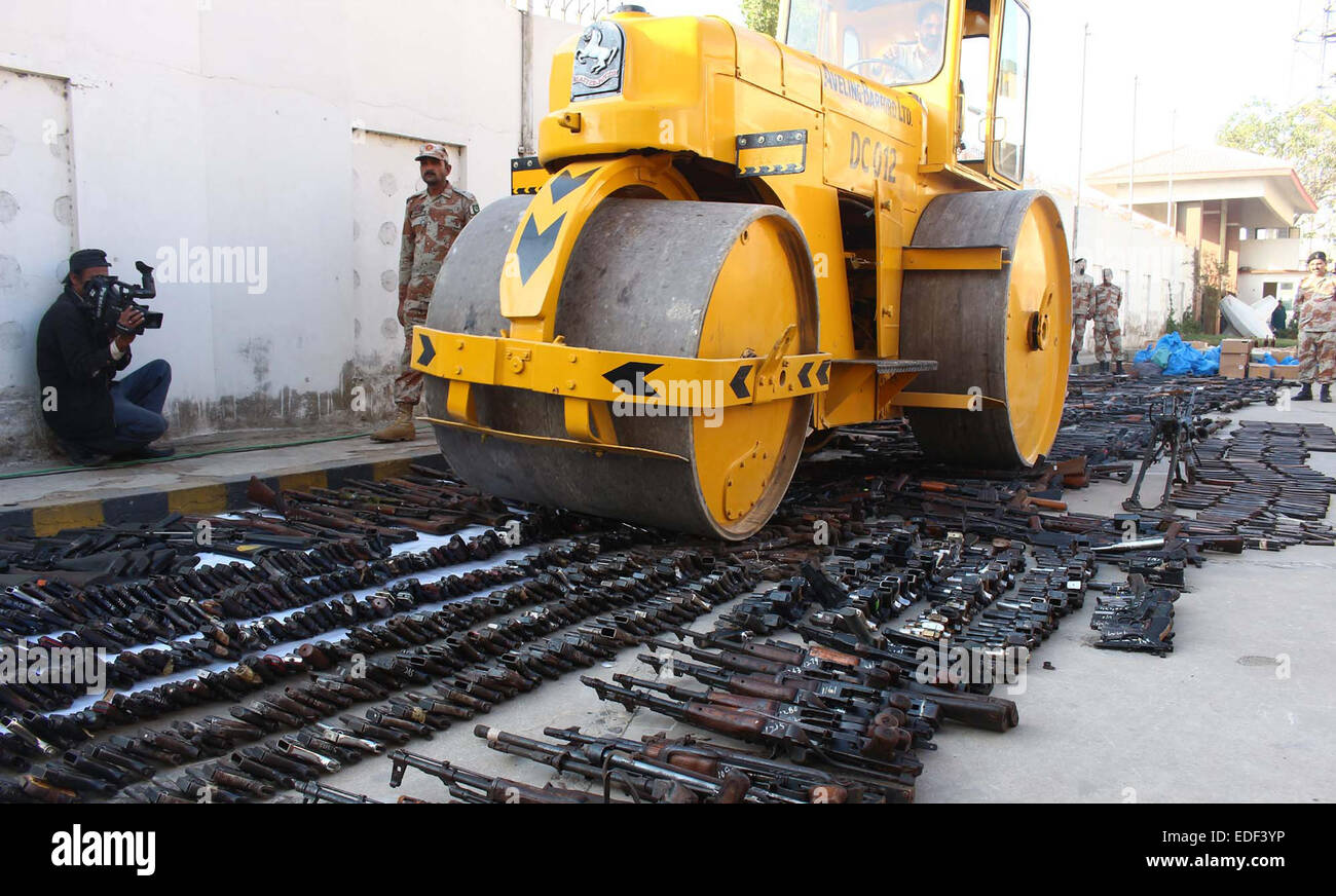 Rouleau de bulldozer lourd détruisant les armes saisies recouvrés au cours de raids dans différentes parties de Karachi à l'aile 93 Rangers du Sind à Karachi le Mardi, Janvier 06, 2015. Rangers du Sind a détruit un grand nombre d'armes saisies et l'énorme quantité de bouteilles de liqueur alcoolique dans la perception du terrorisme et de la criminalité campagne de cessation pour maintenir la paix, la loi et l'ordre dans la région métropolitaine. Banque D'Images