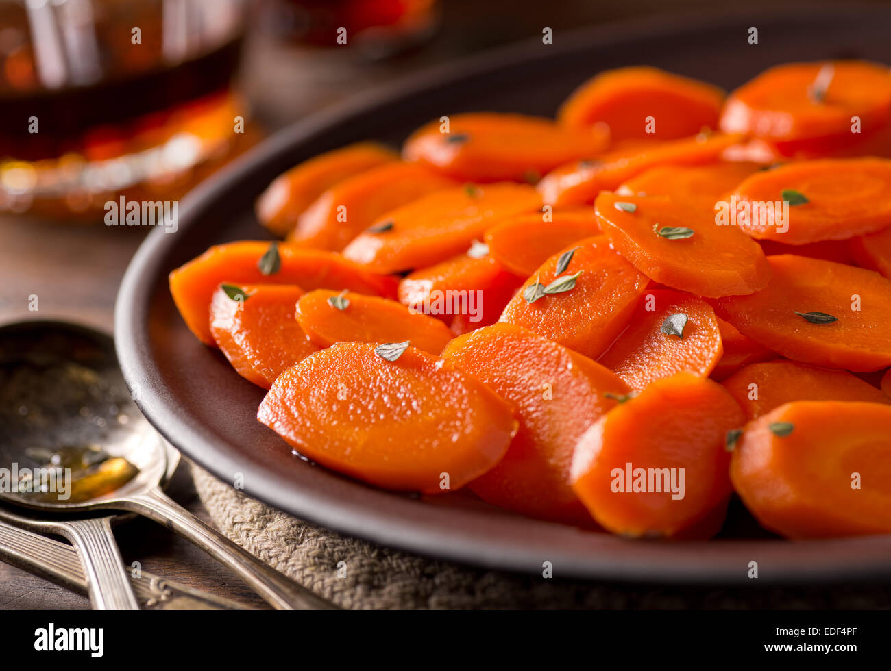 Une assiette de carottes glacées à l'érable délicieux avec le thym. Banque D'Images