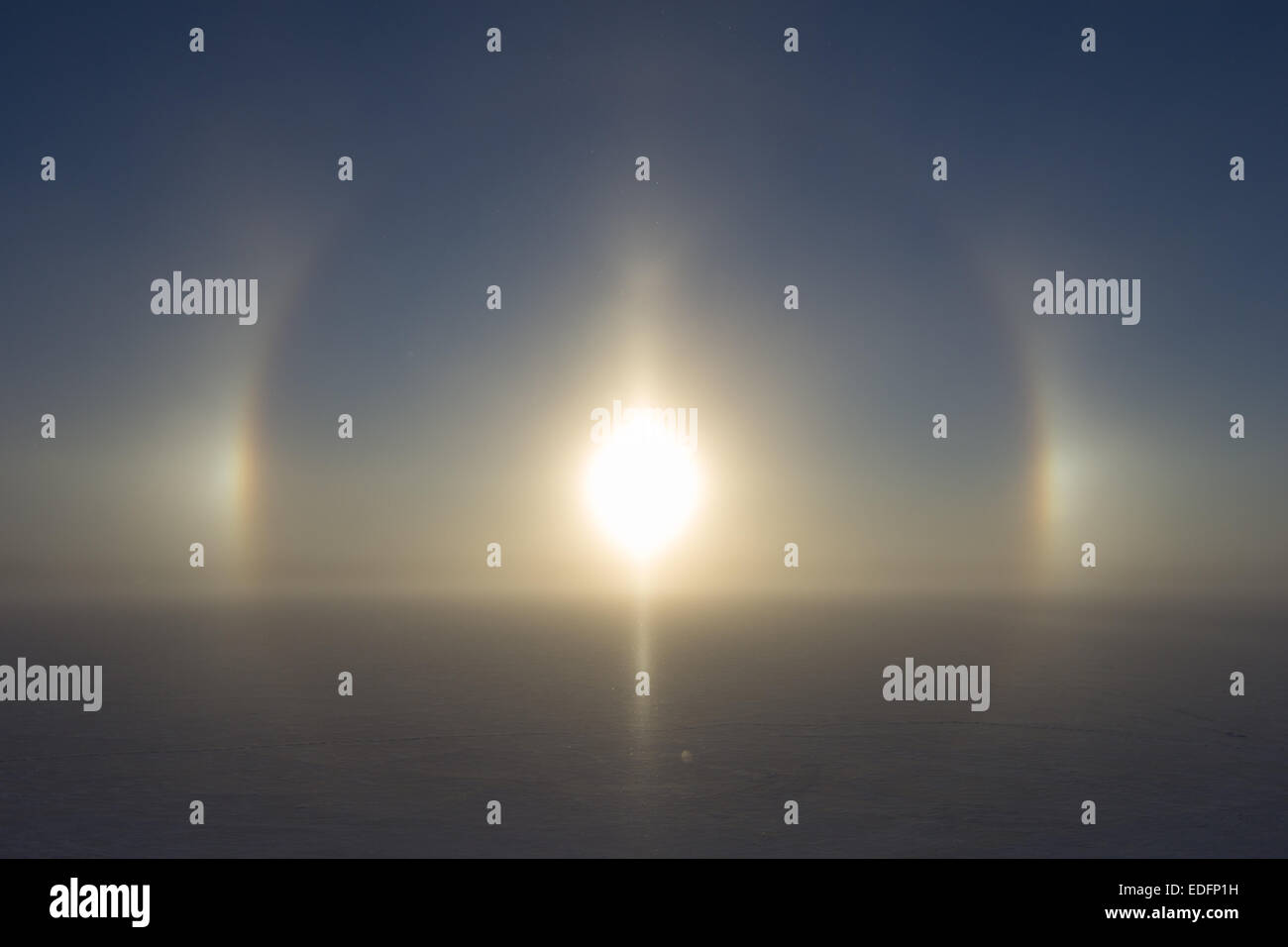 Halo circulaire (22° degré halo) (également connu sous le nom de Nimbus, icebow ou gloriole) autour du soleil sur le lac gelé et enneigé en Finlande Banque D'Images