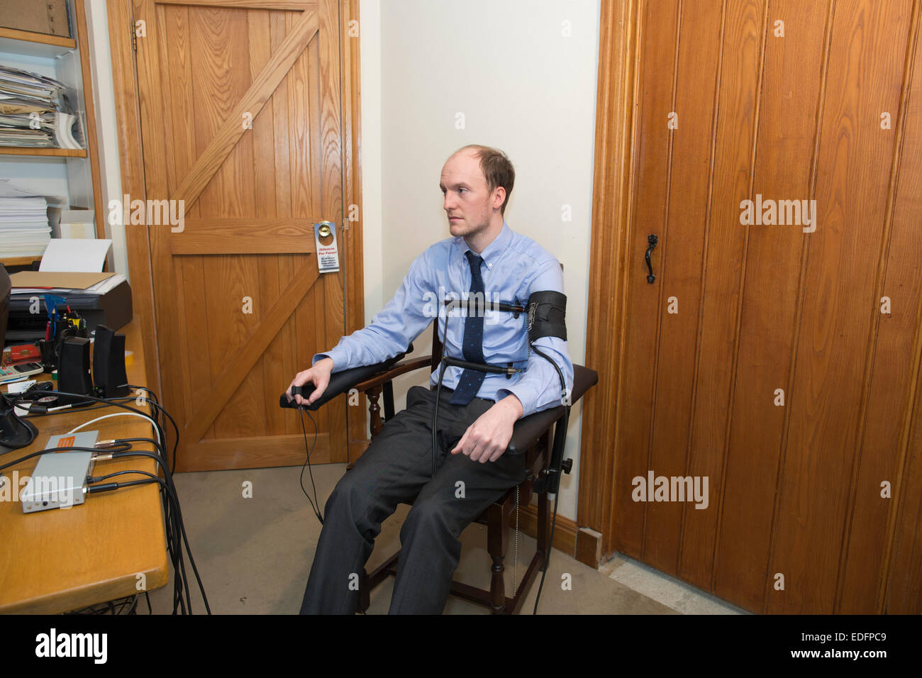 L'homme en cours d'examen à l'aide d'un polygraphe détecteur de mensonge machine qui compare les réponses à certaines des questions pour obtenir la vérité Banque D'Images