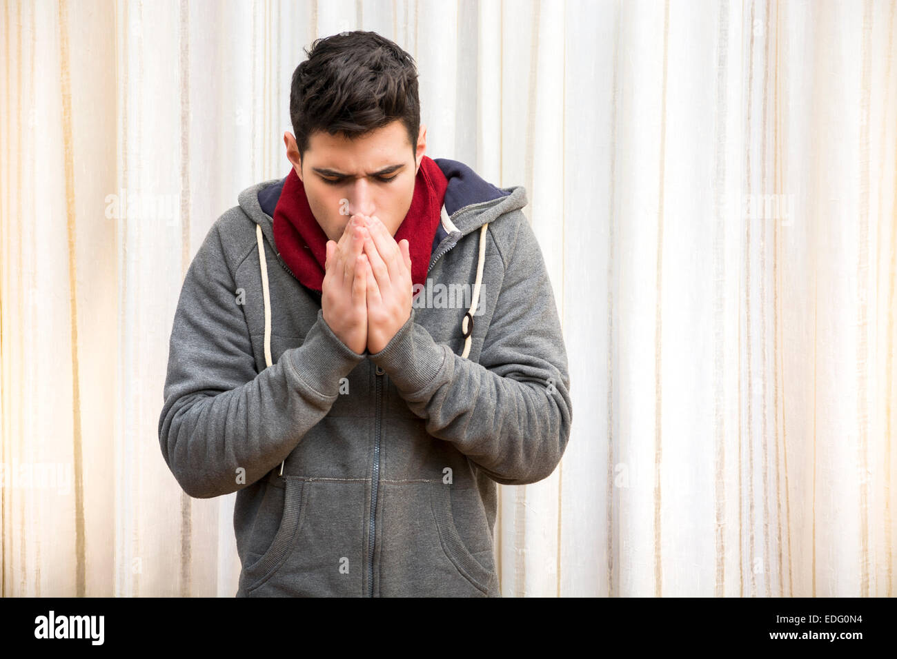 Jeune homme se sentir très froid, porter des pull et foulard Banque D'Images
