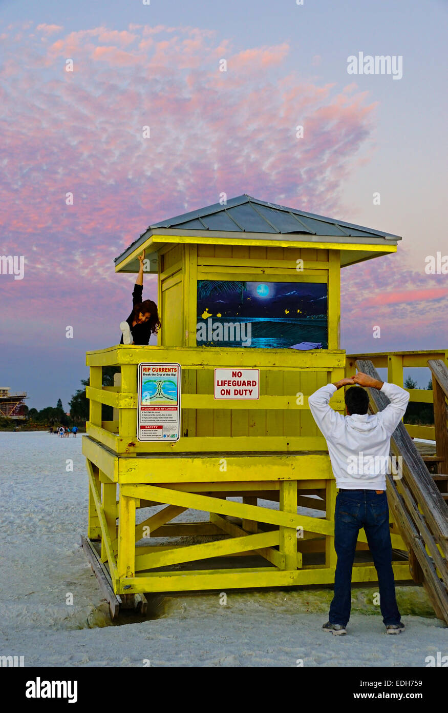 Siesta Key Beach lifeguard tower avec couple exercising au coucher du soleil à Sarasota, Floride. Banque D'Images