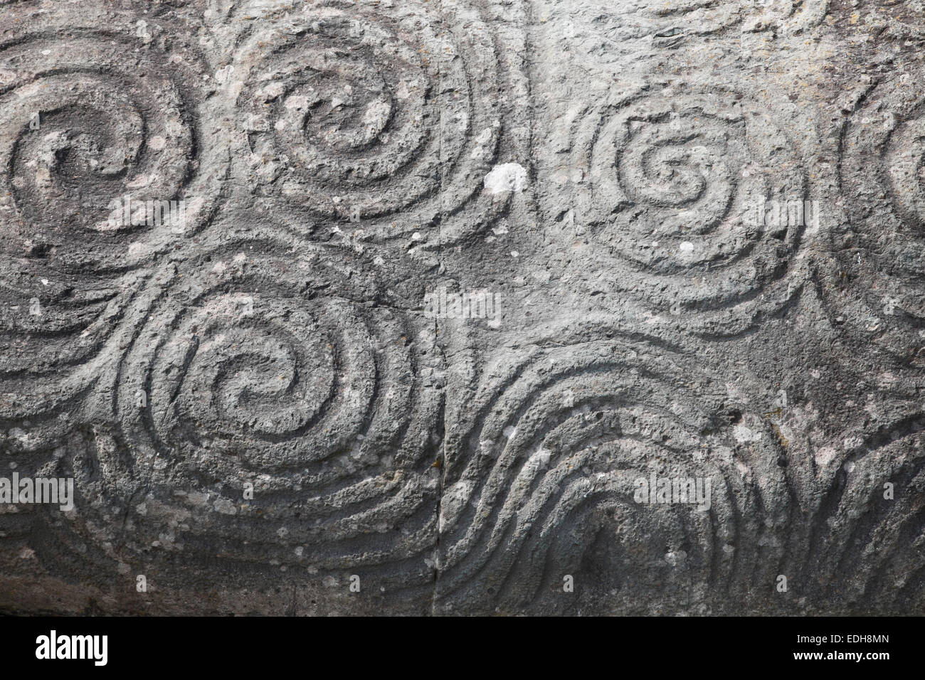 La triple spirale (Symbole celtique) gravé sur une pierre à l'entrée de Newgrange, Bru na Boinne, comté de Meath, Irlande Banque D'Images