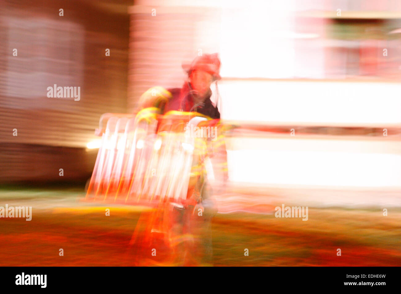 Pompier transportant une échelle d'une scène de Milwaukee incendie brouillé dans Motion Banque D'Images