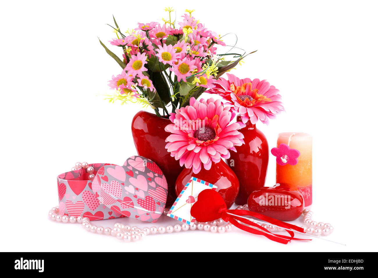 Fleurs dans un vase, verre coeur rouge, collier, coffrets cadeaux et bougies isolé sur fond blanc. Banque D'Images