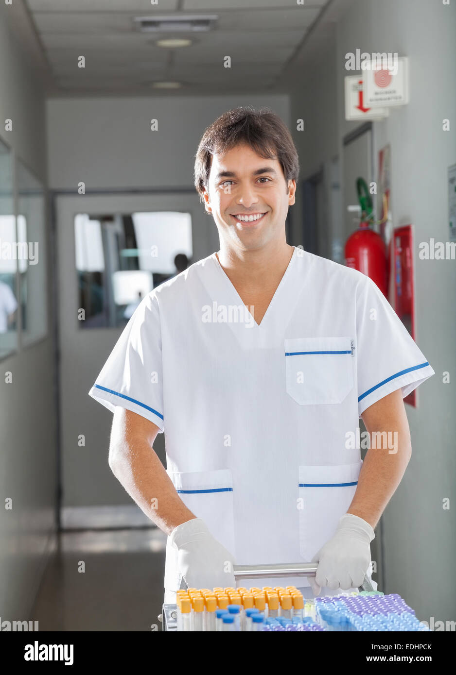Poussant technicien medical cart in hospital hallway Banque D'Images