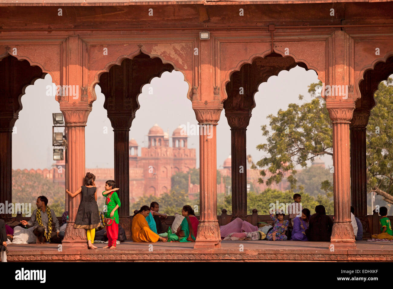 Colonnade dans la cour de la mosquée de vendredi Jama Masjid, le Fort Rouge à l'arrière, Delhi, Inde Banque D'Images