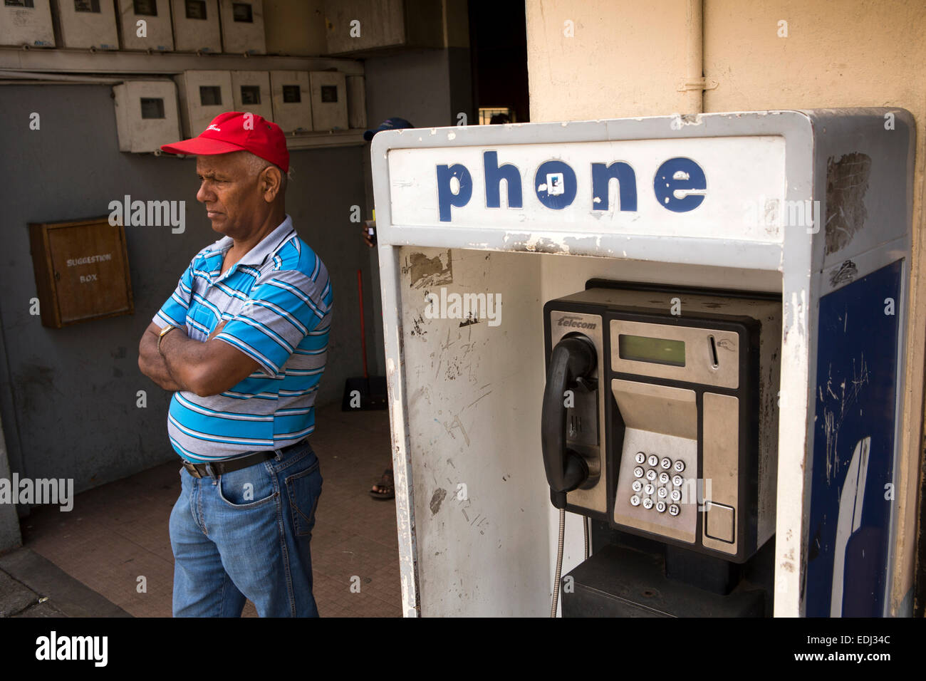 L'Ile Maurice, Quatre Bornes, St Jean Road, l'homme à attendre en cabine téléphonique Banque D'Images