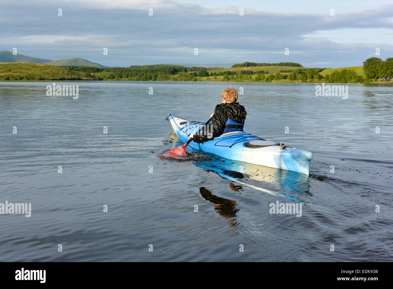 Jeune garçon dans un kayak sur Killington L:ake, Cumbria, Royaume-Uni Banque D'Images