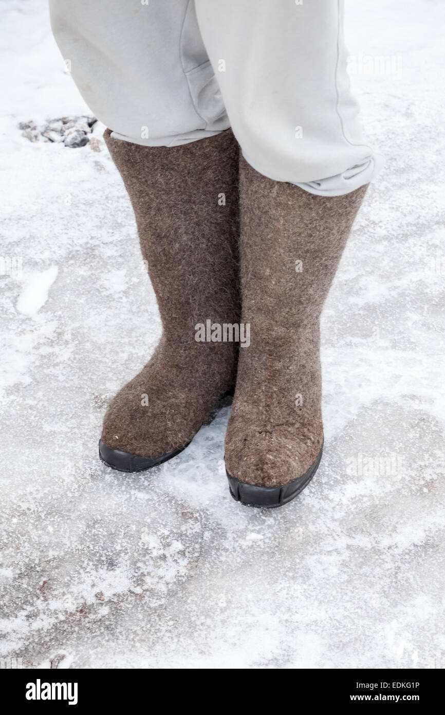 Pieds avec des bottes de feutre gris traditionnel russe se tenir sur la  route d'hiver de neige et de glace Photo Stock - Alamy
