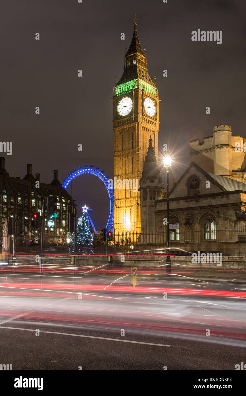 Les chambres du Parlement, Big Ben et le London Eye de nuit avec des stries de trafic. Banque D'Images