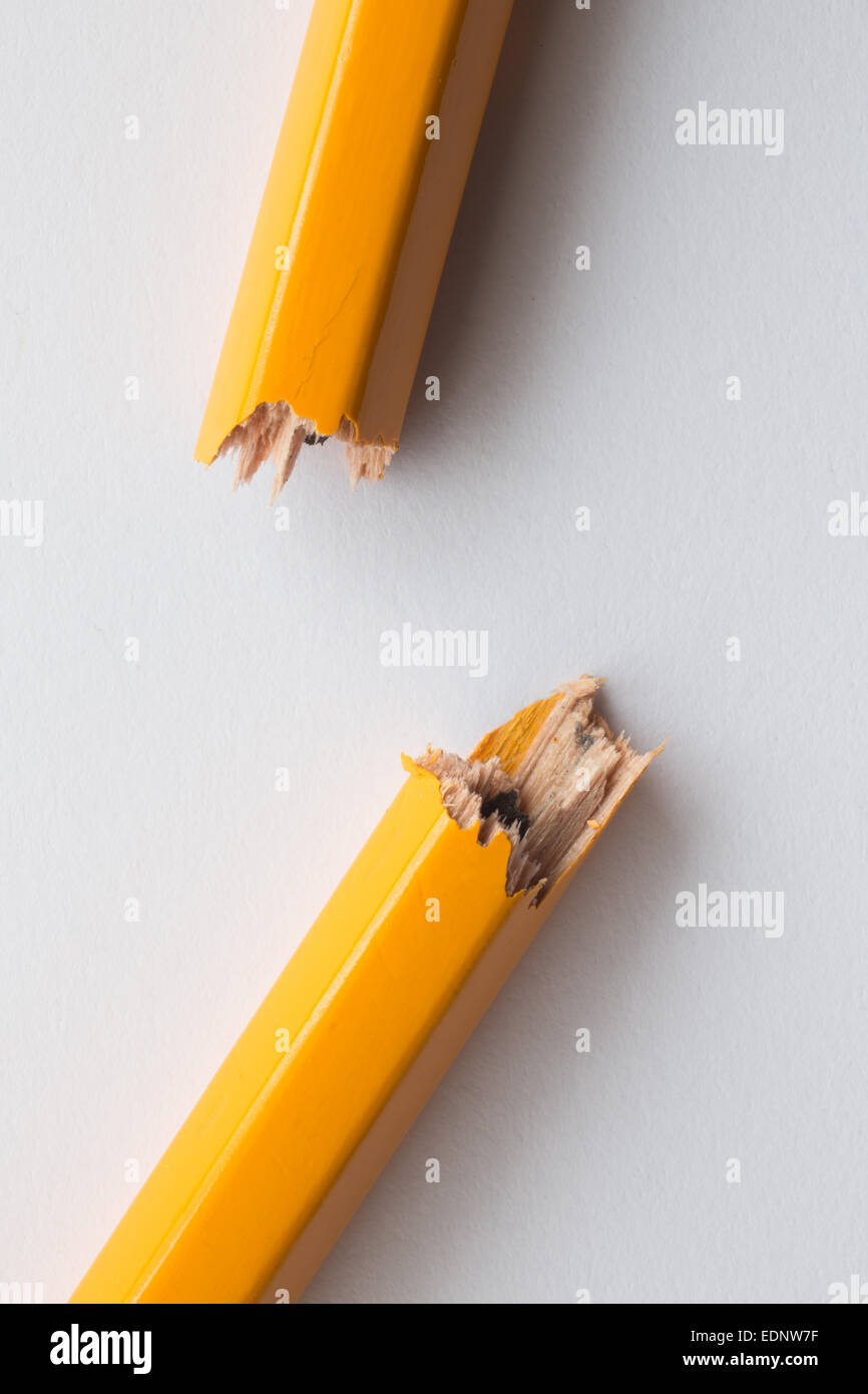Close up / macro d'un crayon jaune cassé ou brisé en deux. Représentant de la réponse relative à l'attaque de Charlie Hebdo Banque D'Images