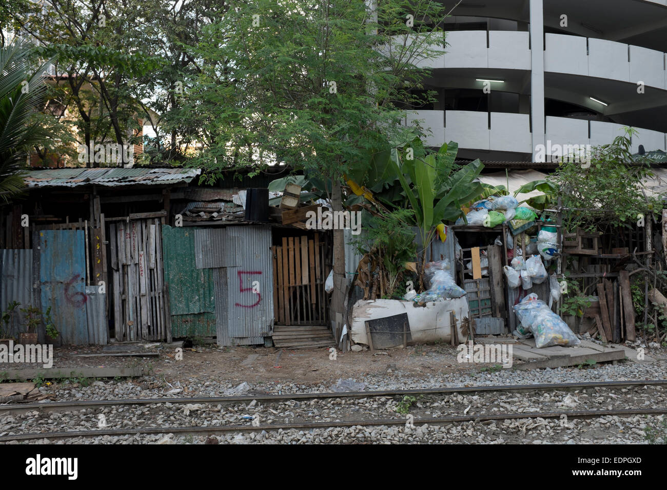 Shanty maisons avec portes numérotées à côté des voies de chemin de fer près de Siam Square, au centre-ville de Bangkok Banque D'Images