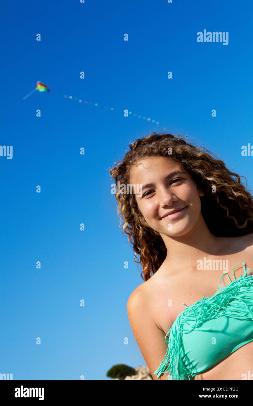 Heureux adolescent à la plage avec un cerf-volant au-dessus de sa tête Banque D'Images