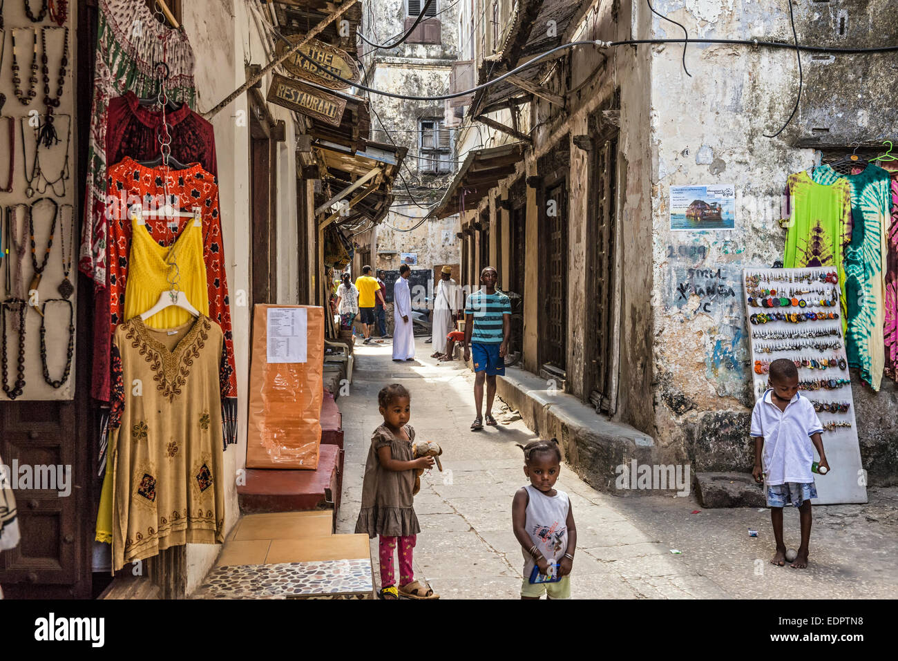 La population locale sur une ruelle typique de Stone Town, Zanzibar Banque D'Images