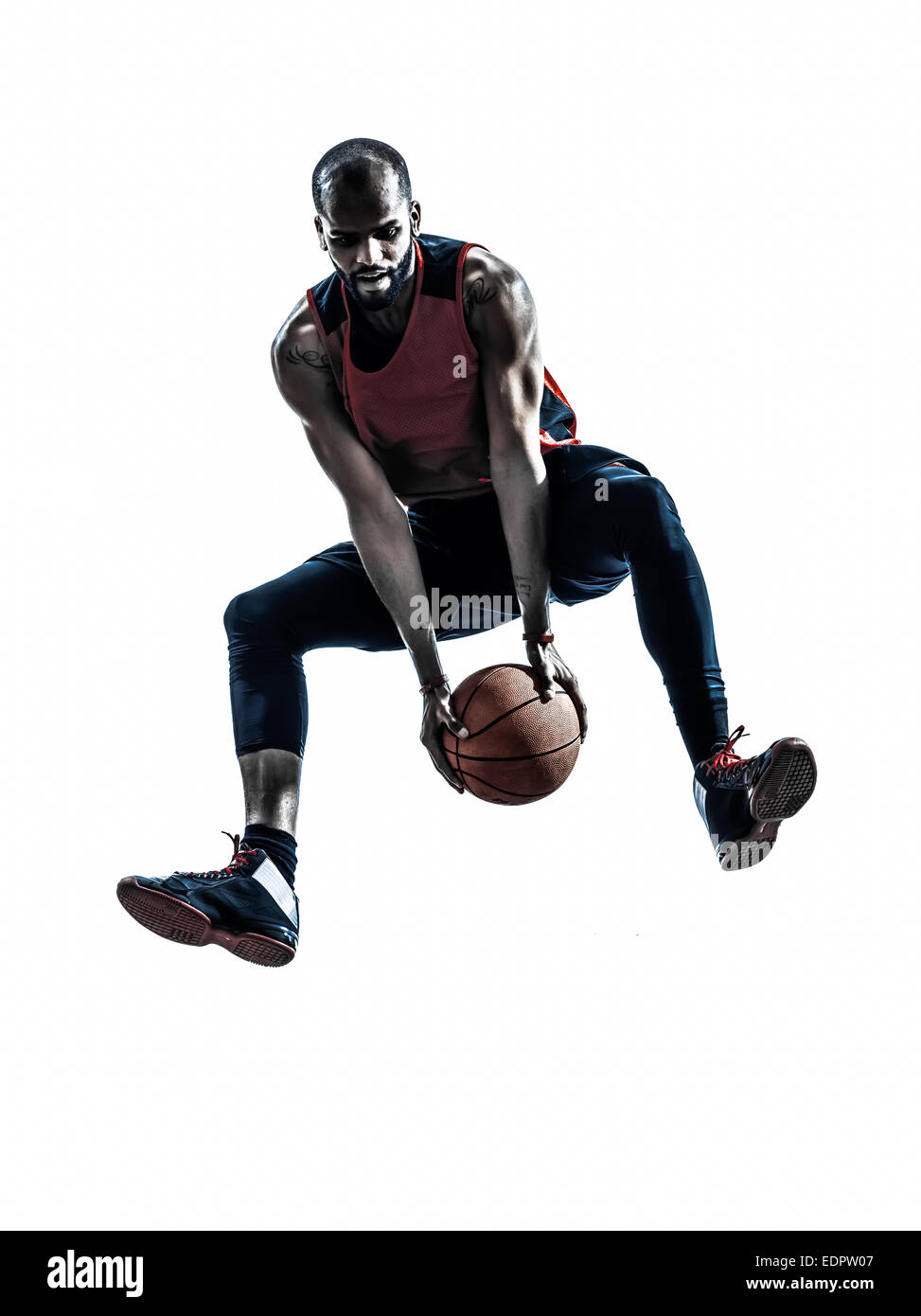 Un homme d'Afrique de basket-ball jumping en silhouette isolé sur fond blanc Banque D'Images