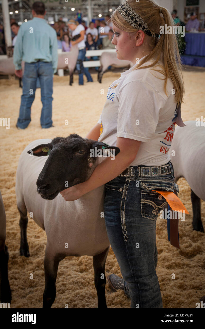 Jeune femme tenant ses moutons dans un salon de la concurrence. Foire de l'état de l'Iowa, Des Moines. Banque D'Images