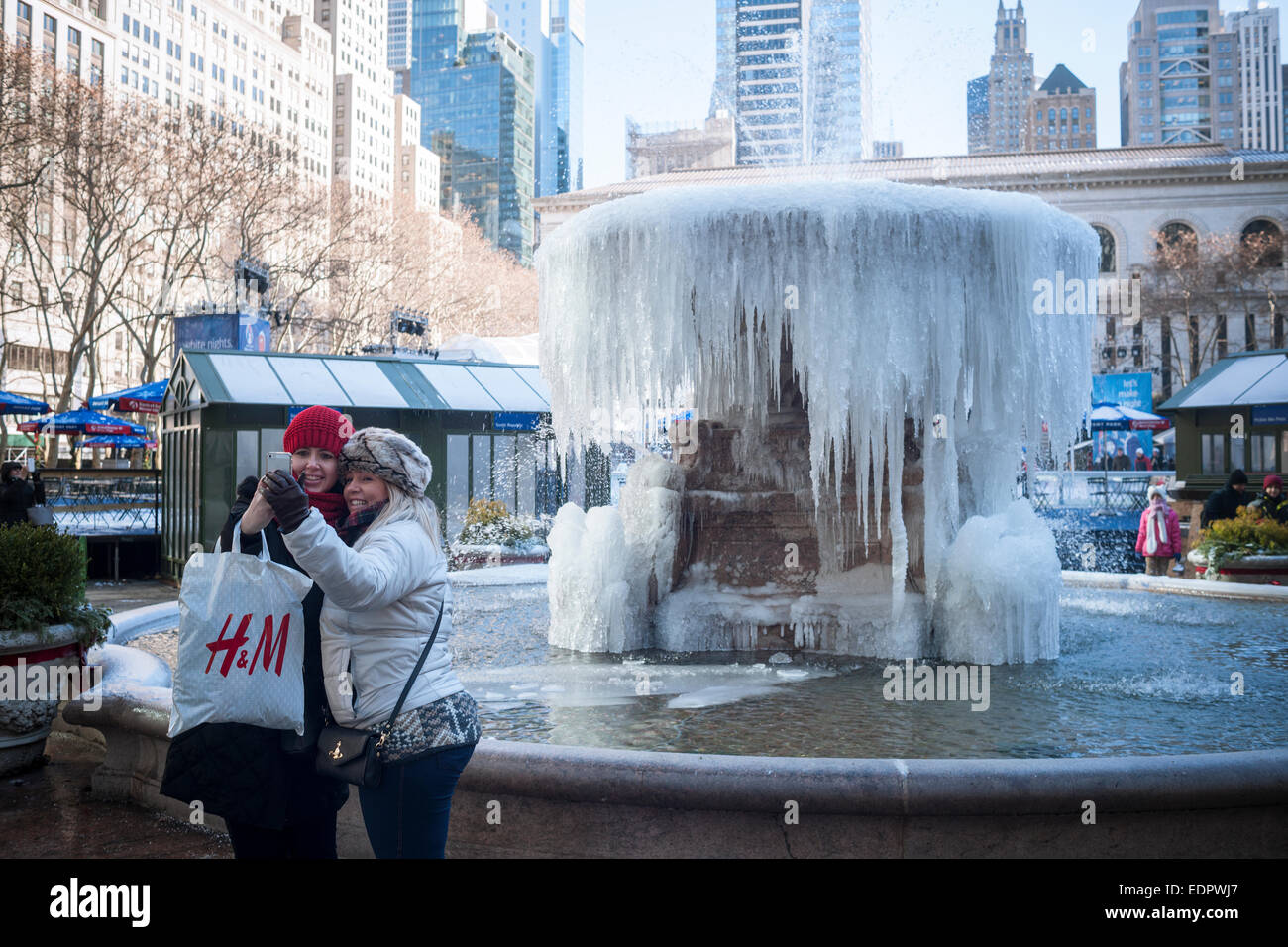 New York, USA. 8 janvier, 2015. Les visiteurs de Bryant Park à New York s'arrêtent à la Josephine Shaw Lowell Memorial fontaine qui est devenu une sculpture de glace par temps froid, le jeudi 8 janvier 2015. Les températures dans la ville sont à 10  % et de l'adolescence avec le vent faible ce qui semble comme 15 degrés en dessous de zéro. Crédit : Richard Levine/Alamy Live News Banque D'Images