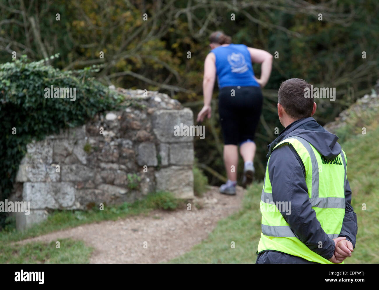 Une course de cross-country runner une femme montres maréchal approche soigneusement une descente raide Banque D'Images