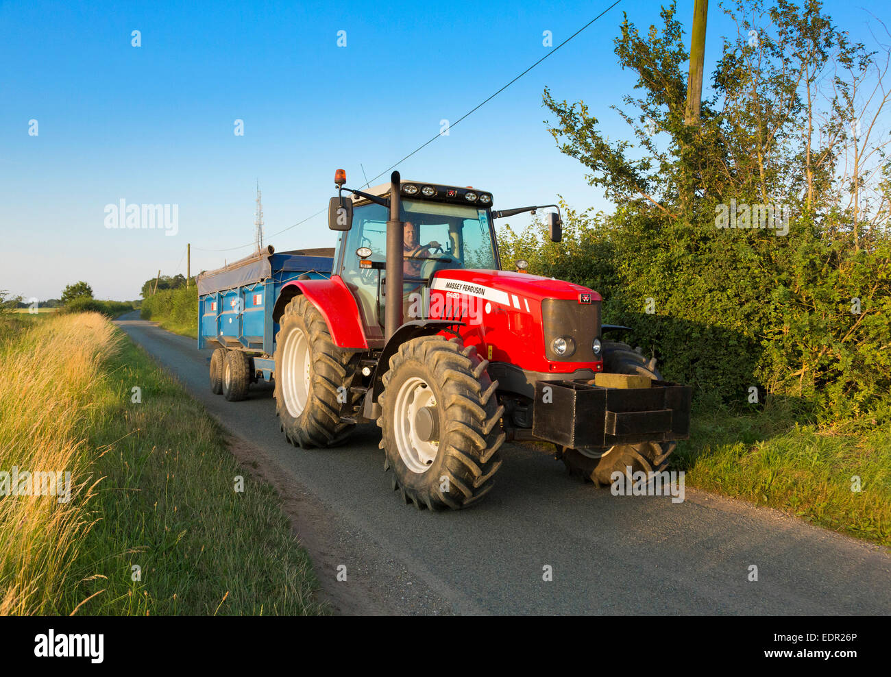 Conduite du tracteur le long de routes de campagne, dans le Suffolk, UK Banque D'Images