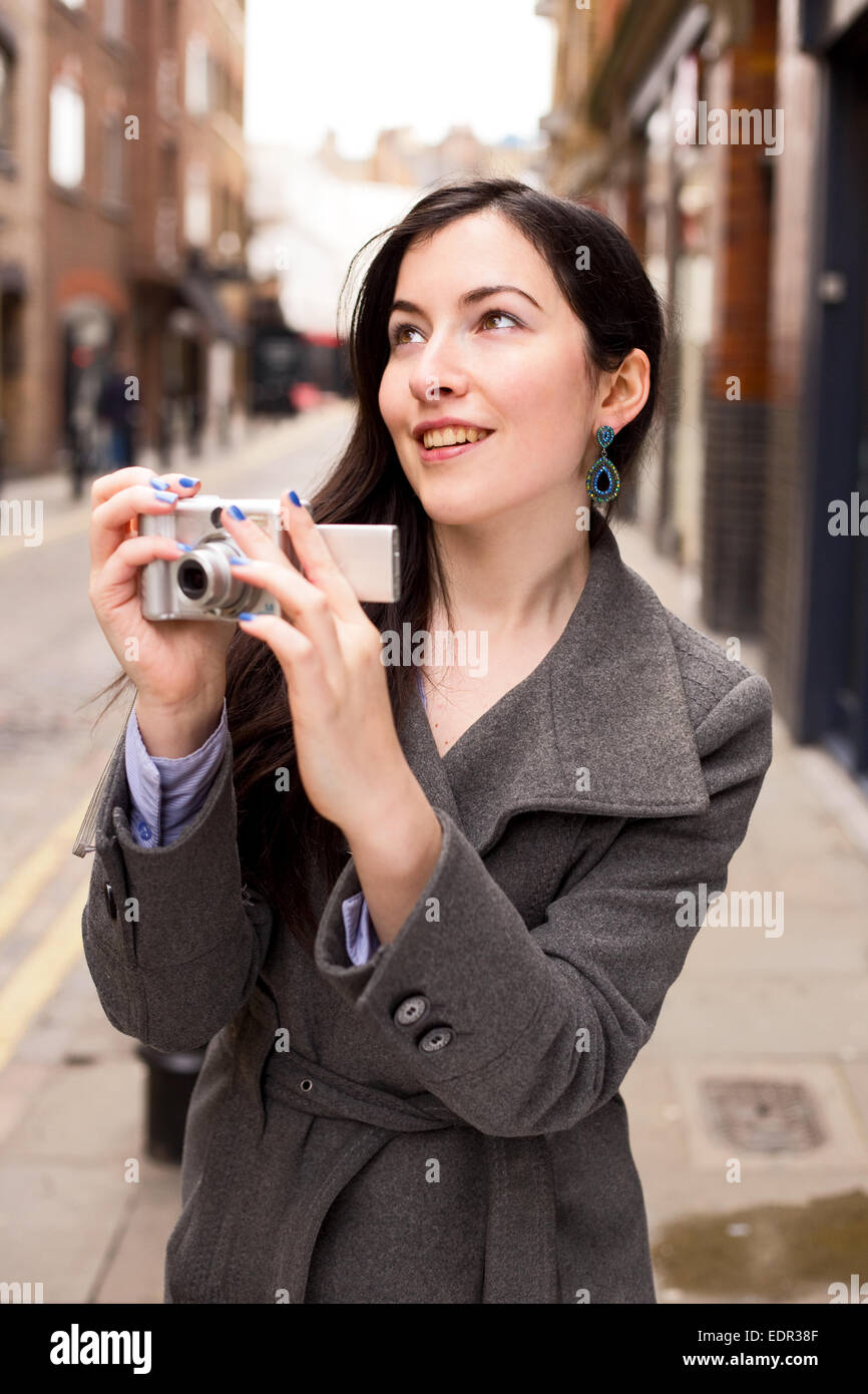 Young woman holding a camera Banque D'Images