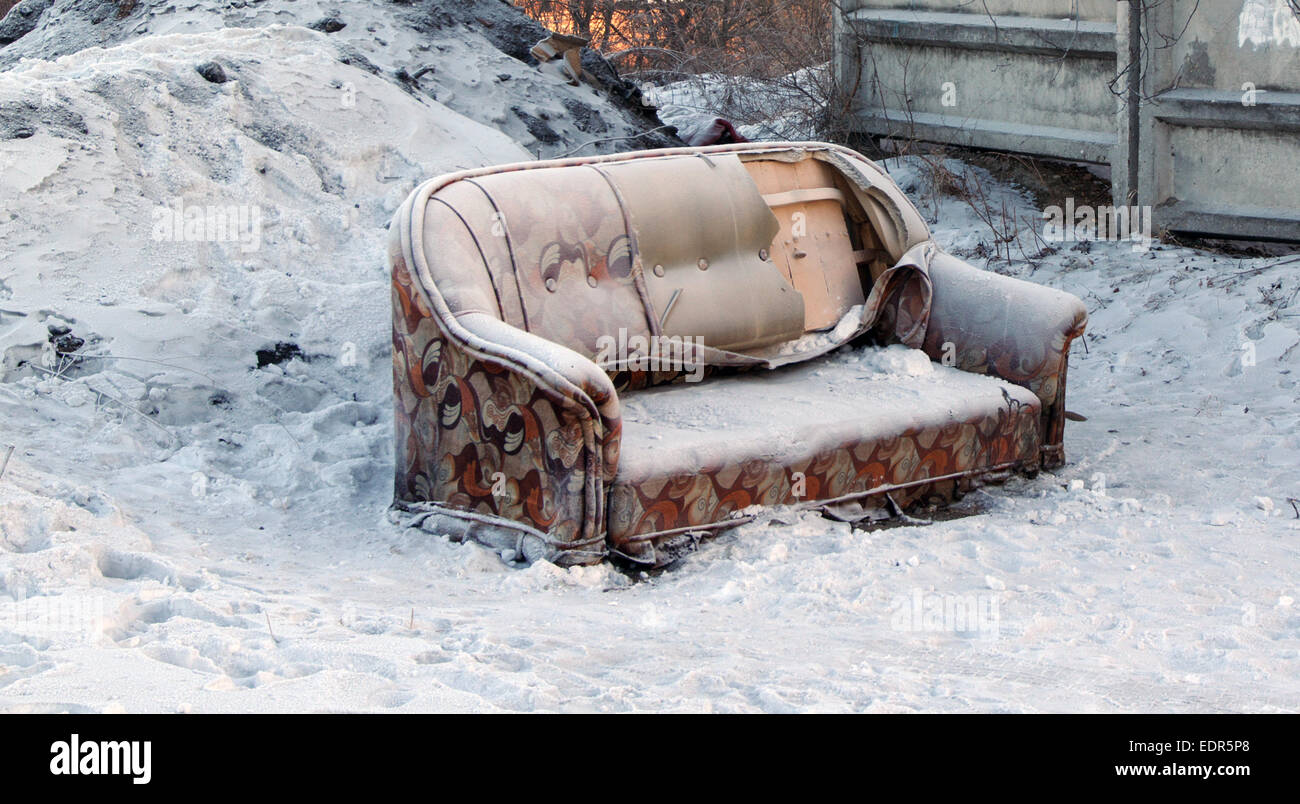 Brisure vieux canapé debout dans la neige Banque D'Images