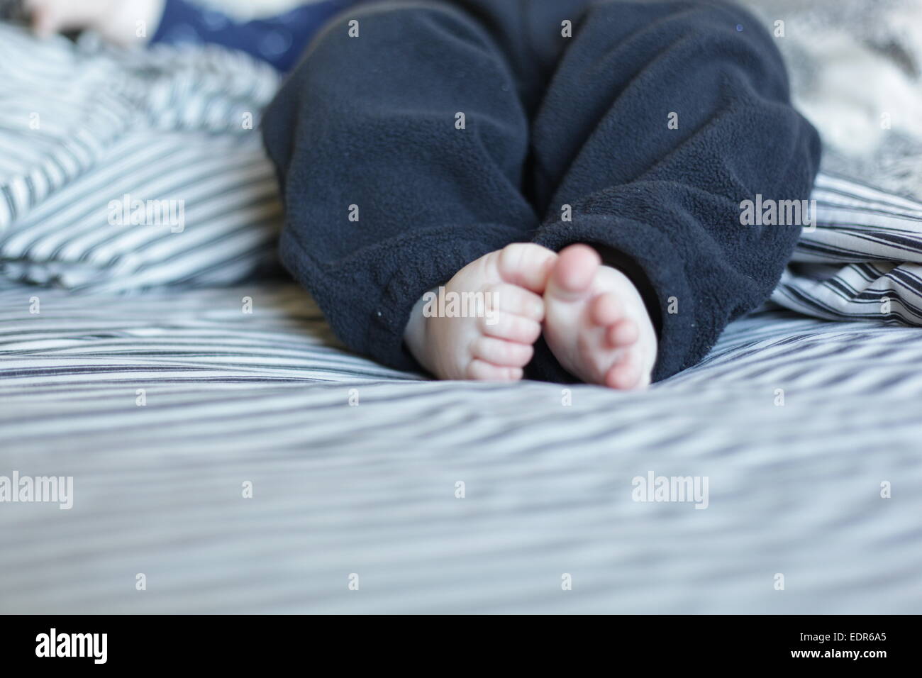 Pieds de bébé sur un lit Banque D'Images