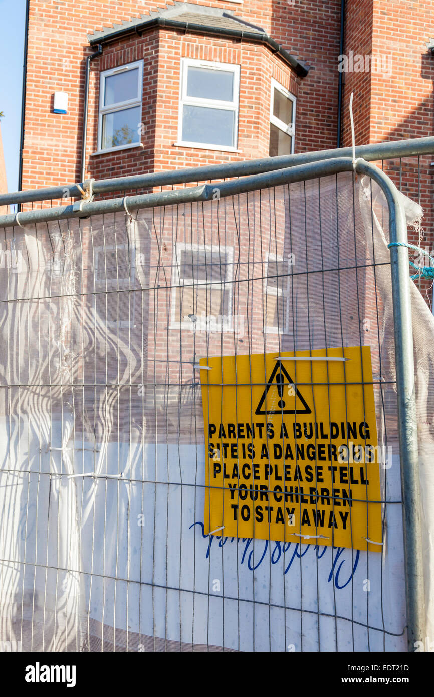 Site de construction signe de danger. Avis d'avertissement aux parents qu'un chantier est un endroit dangereux et de dire aux enfants de rester à l'écart, England, UK Banque D'Images