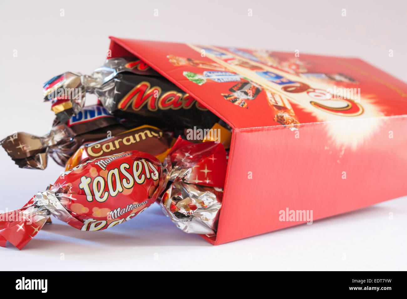 Boîte de chocolats célébrations ouvert avec table des matières déversées ensemble renversé sur fond blanc Banque D'Images