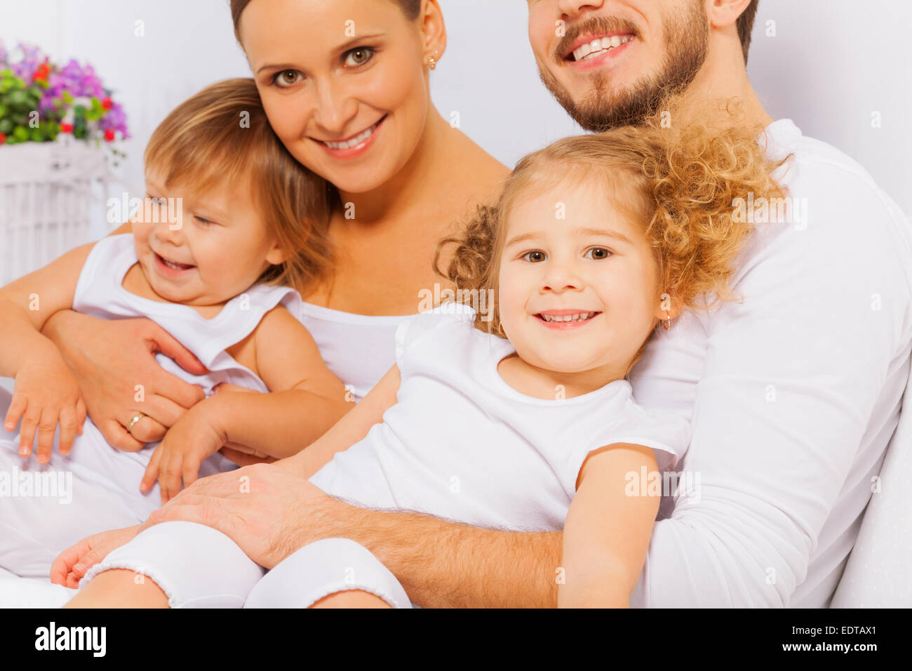 Heureux parents de deux adorables enfants on bed Banque D'Images