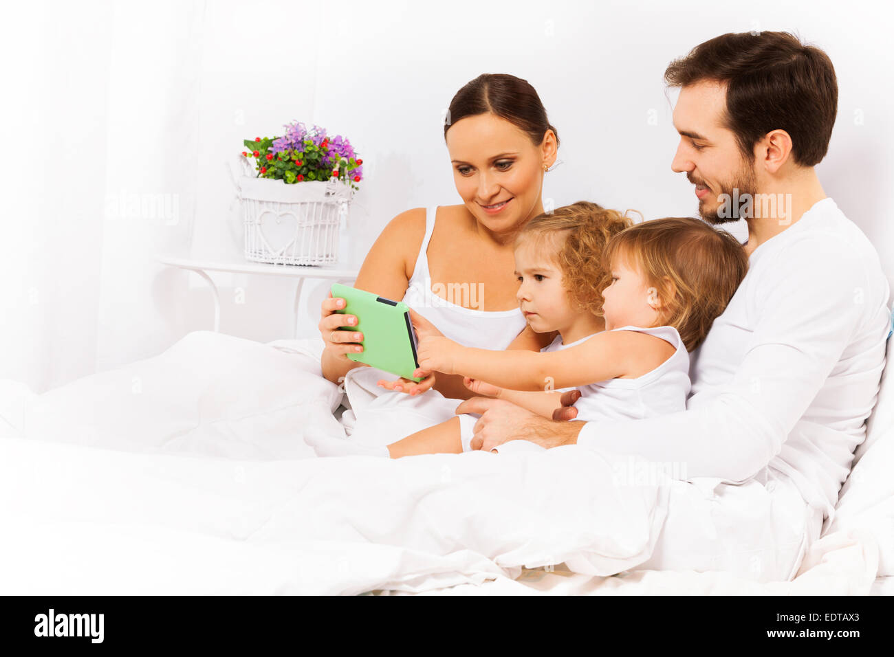 Heureux parents avec deux enfants regarder tablet Banque D'Images