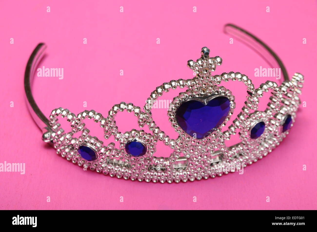 Tiara jouet avec diamants et perle bleu, comme une princesse couronne sur fond rose Banque D'Images