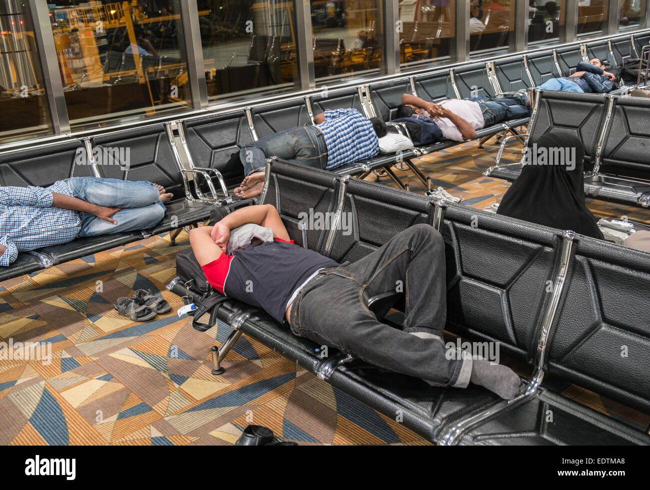 Dormir,dormir,privé,privation,somnoler,reposant,rattraper un peu de sommeil,au départ,l'Aéroport International de Bahreïn, Bahreïn, Moyen-Orient Banque D'Images