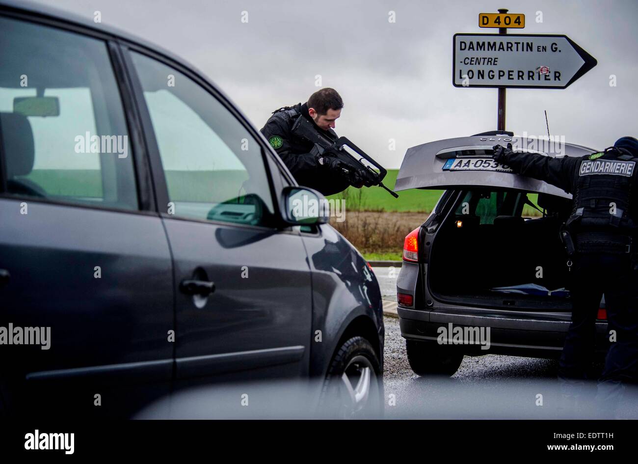 Dammartin-en-Goele, France. 9 janvier, 2015. Un policier vérifie une voiture à Dammartin-en-Goele, au nord-est de Paris, où deux frères soupçonnés d'attaque Charlie Hebdo a tenu une personne en otage comme les hommes armés à coins de la police, le 9 janvier, 2015. La force de sécurité français lancé assaut contre Kouachi frères, tués les deux suspects de l'attaque de Charlie Hebdo. Source : Xinhua/Alamy Live News Banque D'Images Dammartin-en-Goele, France. 9 janvier, 2015. Un policier vérifie une voiture à Dammartin-en-Goele, au nord-est de Paris, où deux frères soupçonnés d'attaque Charlie Hebdo a tenu une personne en otage comme les hommes armés à coins de la police, le 9 janvier, 2015. La force de sécurité français lancé assaut contre Kouachi frères, tués les deux suspects de l'attaque de Charlie Hebdo. Source : Xinhua/Alamy Live News Banque D'Images
