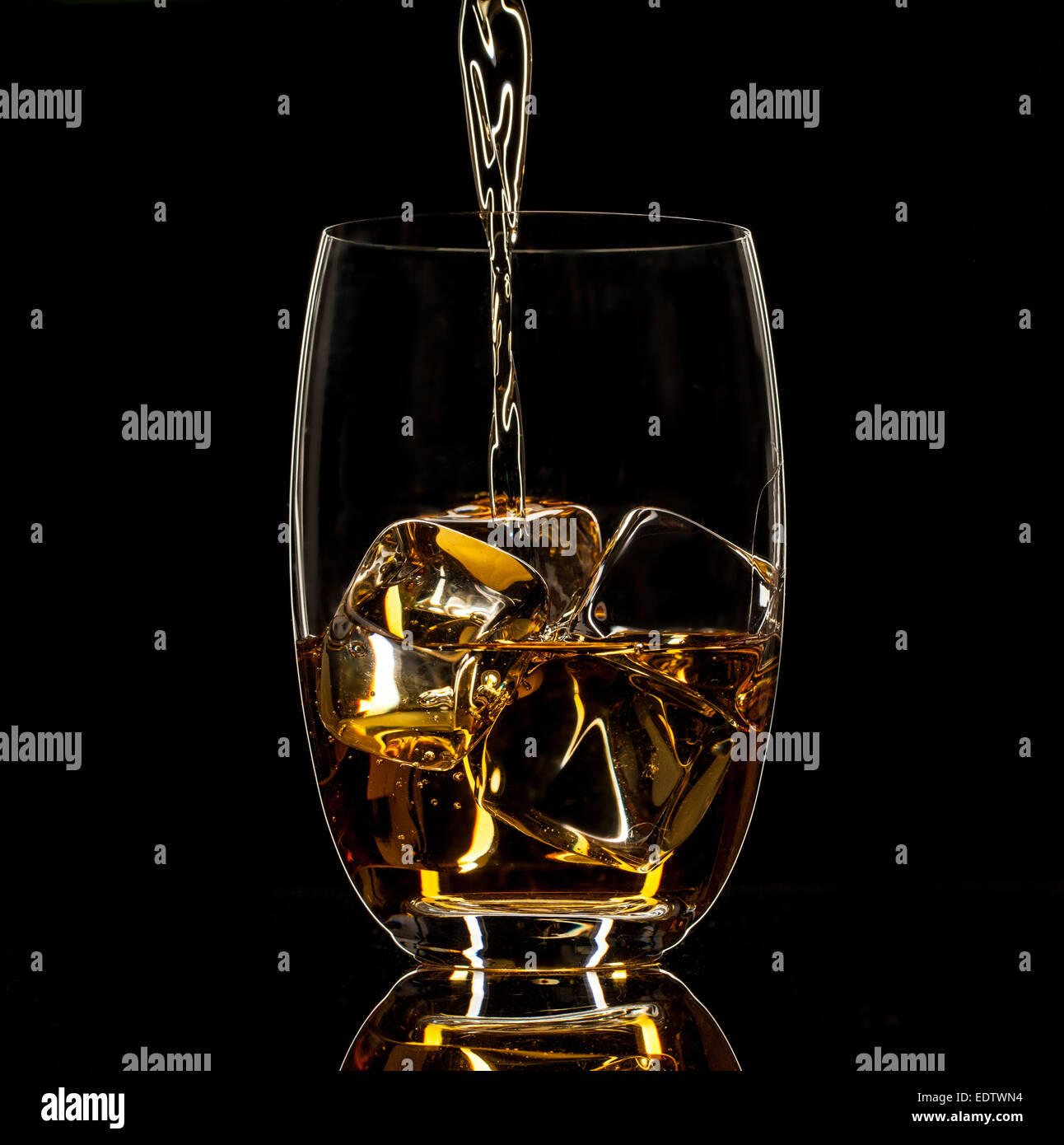 Shot de whiskey isolé avec splash sur fond noir Banque D'Images
