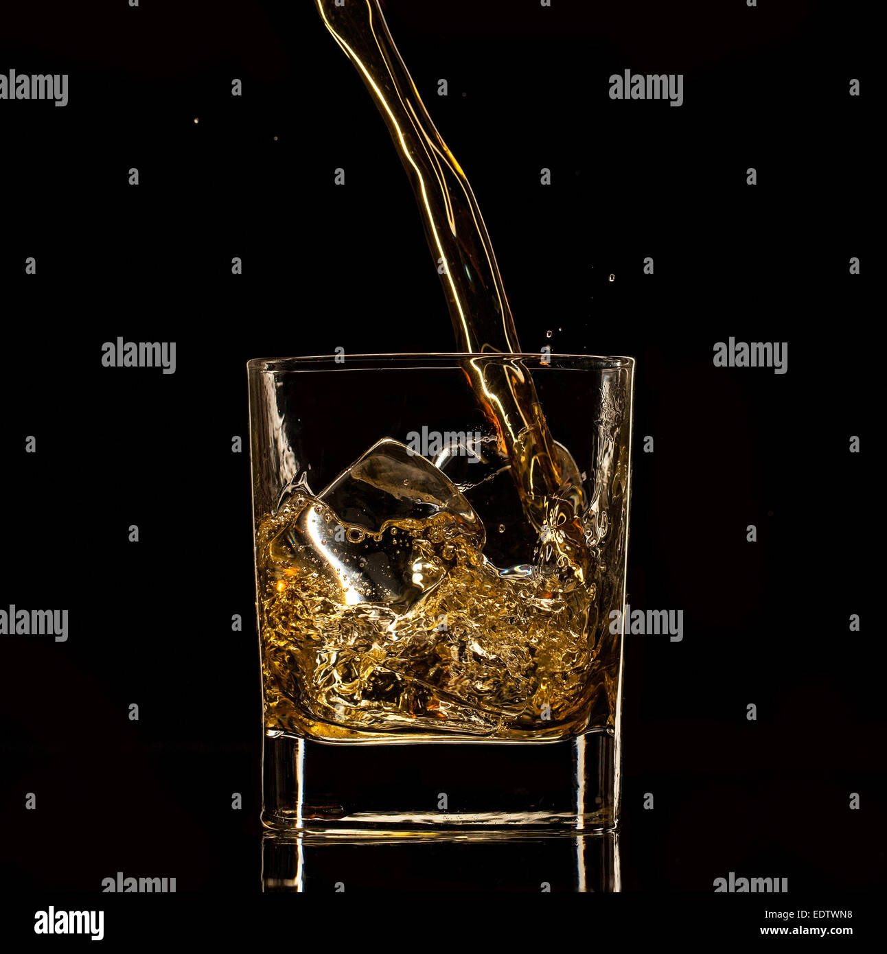 Shot de whiskey isolé avec splash sur fond noir Banque D'Images