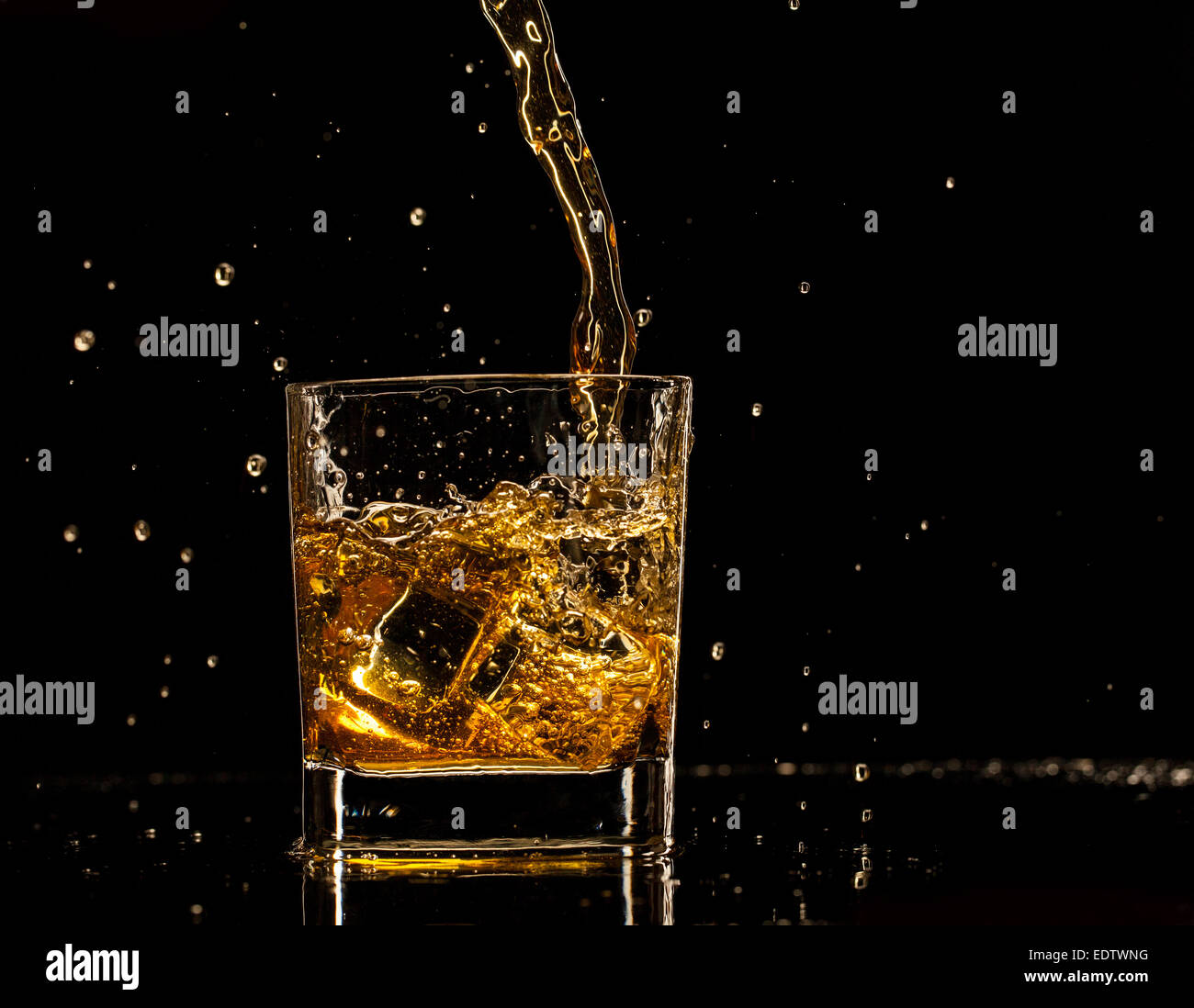 Shot de whiskey isolé avec splash sur fond noir Banque D'Images