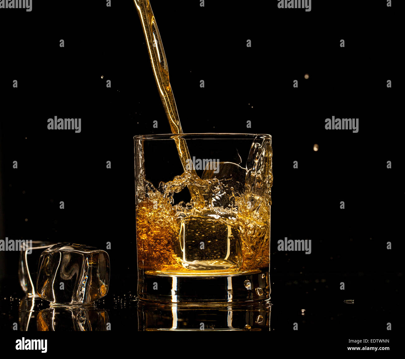 Shot de whiskey isolé avec splash sur fond noir Banque D'Images