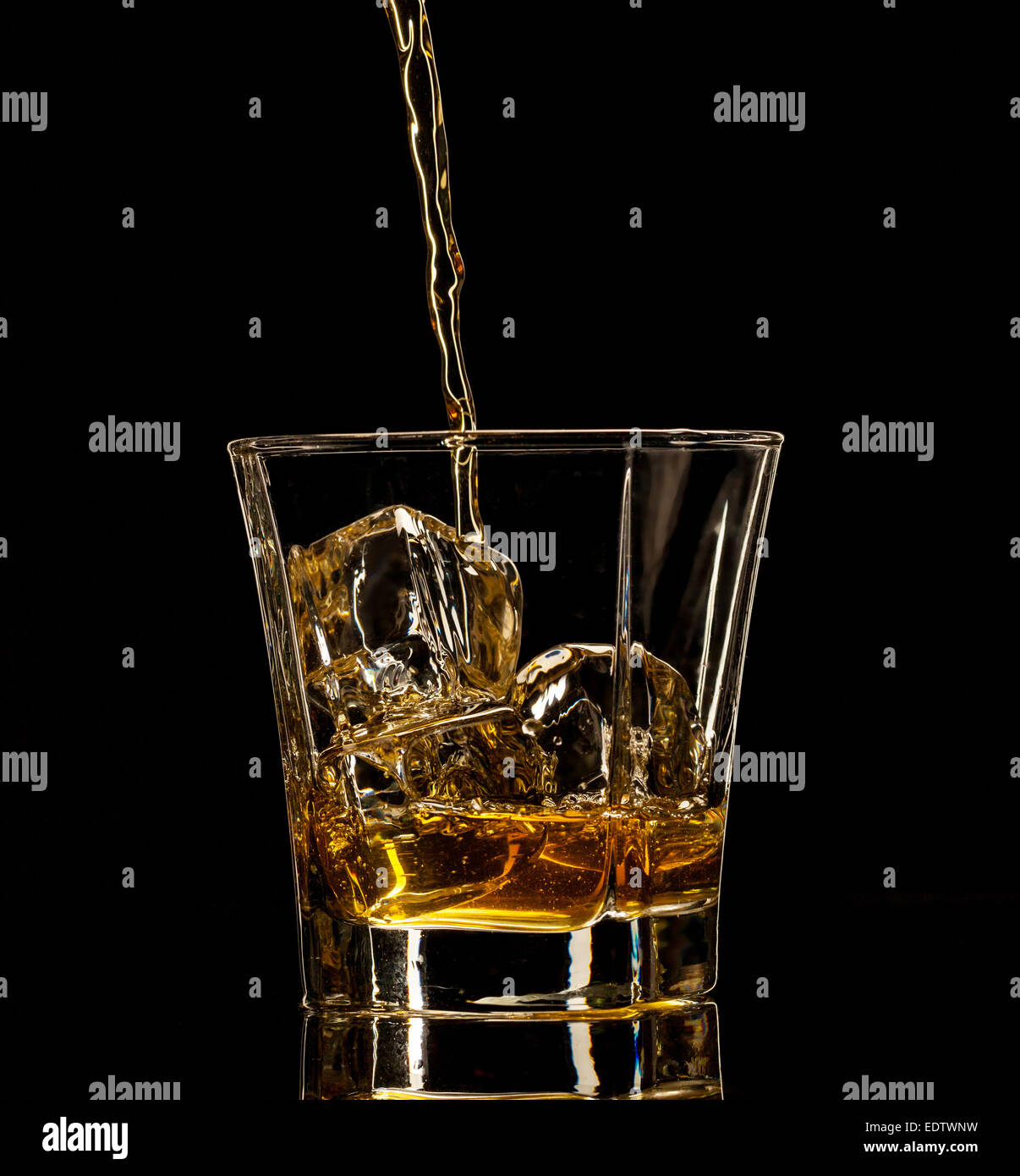 Shot de whiskey isolé avec splash sur fond noir Banque D'Images