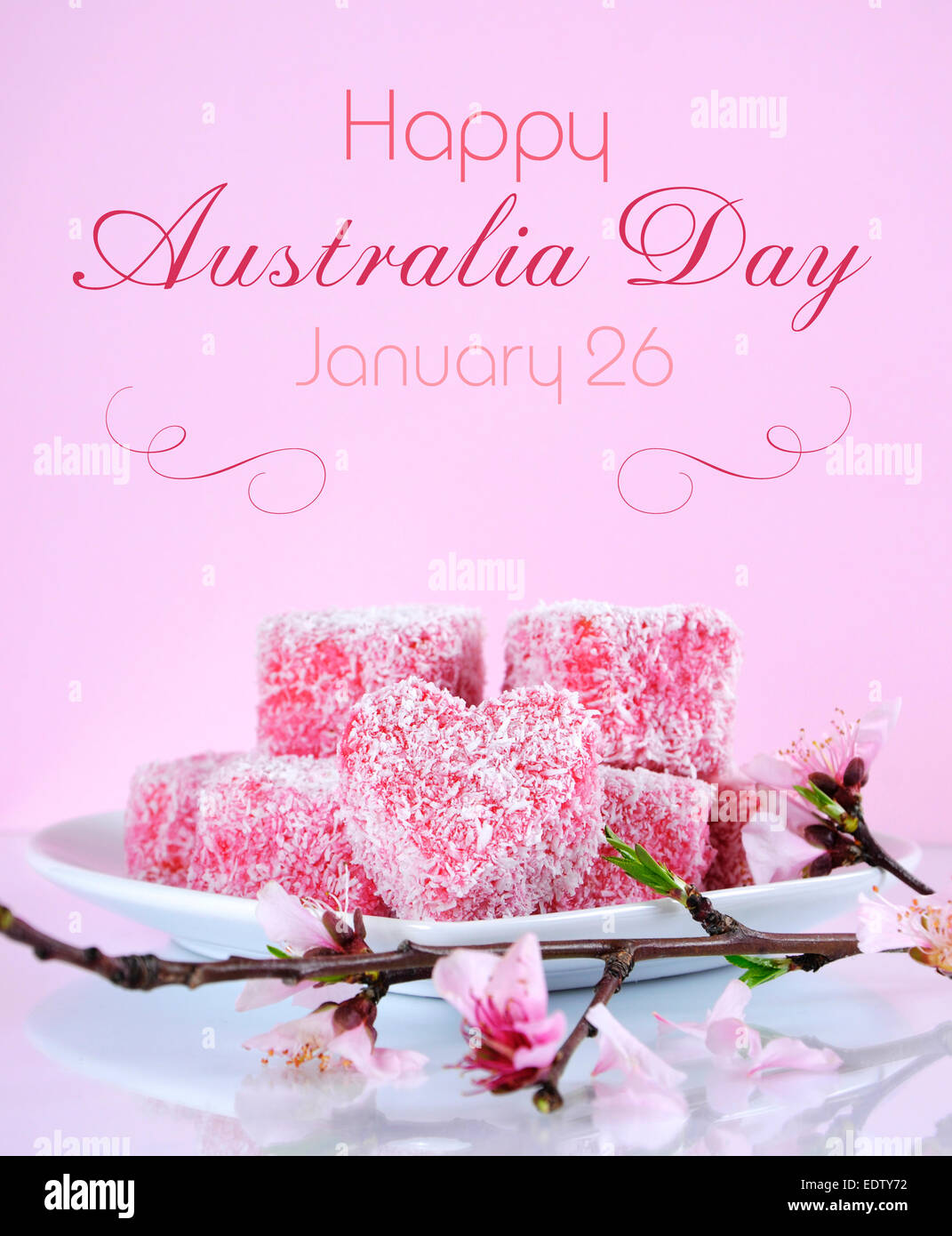Style australien fait maison en forme de coeur rose petits gâteaux lamington avec fleur de printemps sur une table de réflexion Banque D'Images