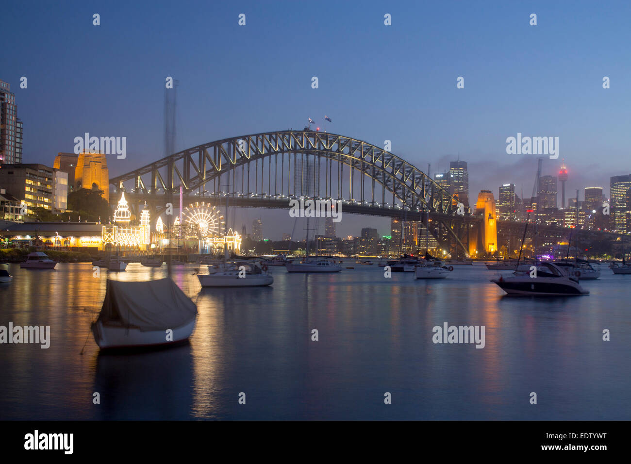 Lavender Bay bateaux en vue sur le port de Sydney Harbour Bridge CBD skyline skyscrapers et Luna Park la nuit Sydney NSW Australie Banque D'Images