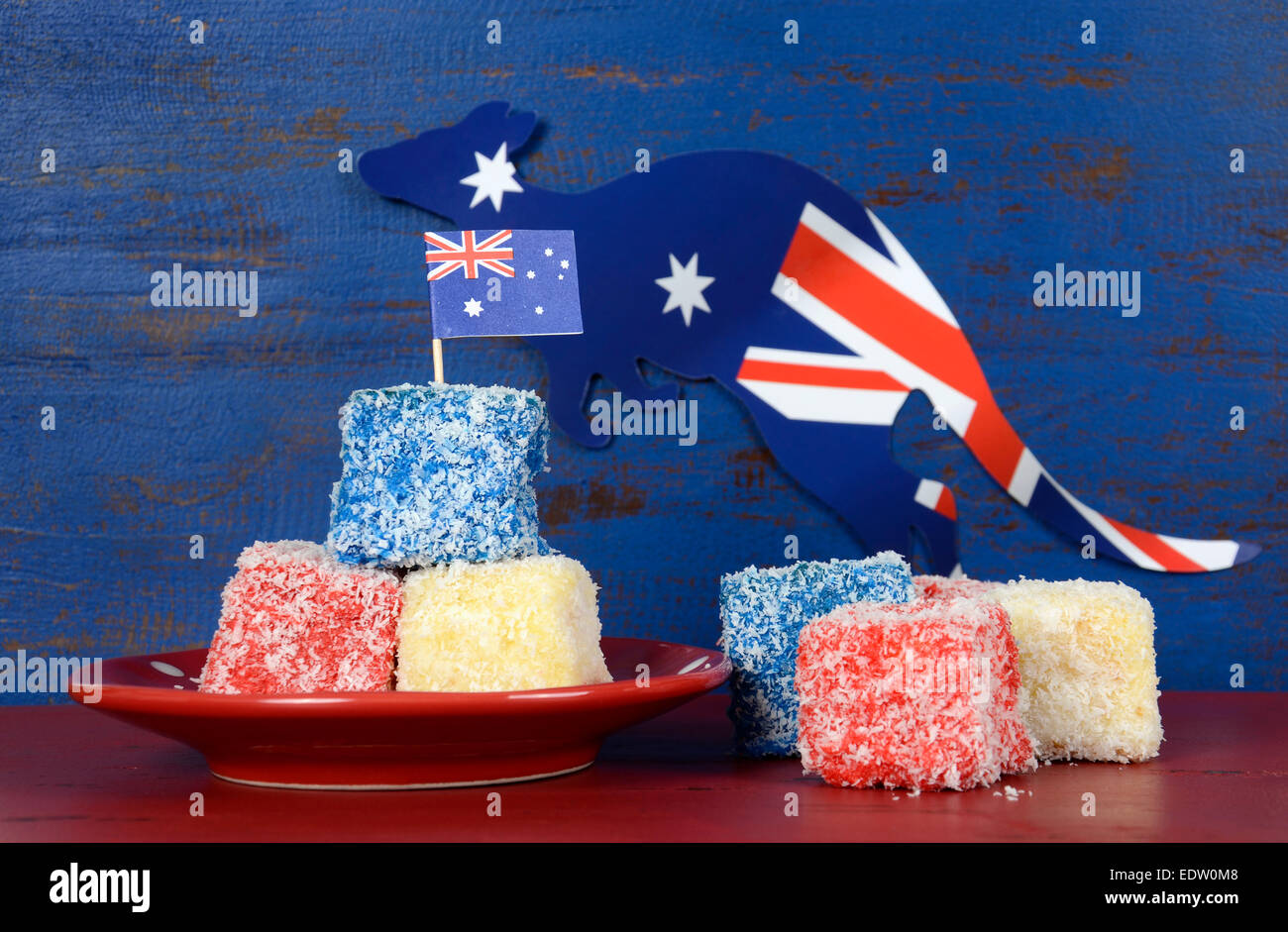 Heureux l'Australie jour rouge, blanc et bleu lamingtons sur rouge et bleu en bois recyclé sombre arrière-plan. Banque D'Images