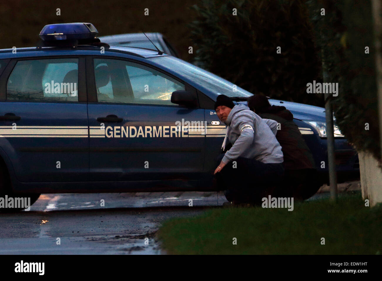 (150110) -- DAMMARTIN-EN-GOELE, 10 janvier 2015 (Xinhua) -- Deux policiers en civil se cacher derrière une voiture de police dans la région de Dammartin-en-Goele, au nord-est de Paris, où deux frères soupçonnés d'attaque Charlie Hebdo a tenu une personne en otage comme les hommes armés à coins de la police, le 9 janvier, 2015. Les frères Kouachi, suspects de Charlie Hebdo, les attaques ont été tués pendant l'assaut des forces de sécurité française le vendredi soir, et les otages sont en vie. (Xinhua/Raoul Chombier) Banque D'Images (150110) -- DAMMARTIN-EN-GOELE, 10 janvier 2015 (Xinhua) -- Deux policiers en civil se cacher derrière une voiture de police dans la région de Dammartin-en-Goele, au nord-est de Paris, où deux frères soupçonnés d'attaque Charlie Hebdo a tenu une personne en otage comme les hommes armés à coins de la police, le 9 janvier, 2015. Les frères Kouachi, suspects de Charlie Hebdo, les attaques ont été tués pendant l'assaut des forces de sécurité française le vendredi soir, et les otages sont en vie. (Xinhua/Raoul Chombier) Banque D'Images