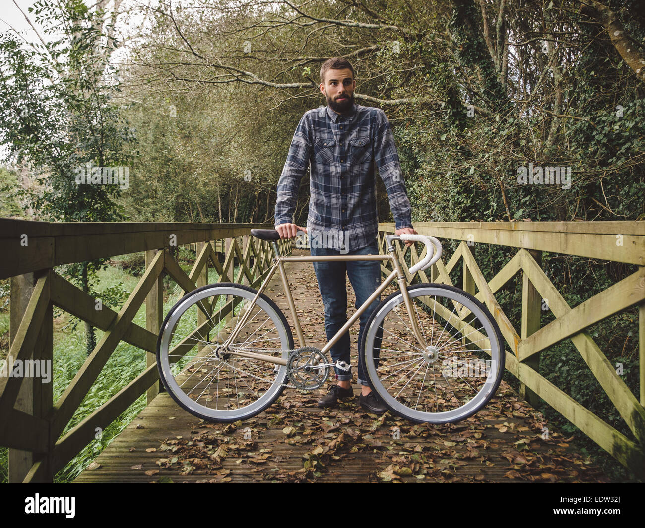 Hipster homme avec son fixie vélo dans un parc de la ville Banque D'Images