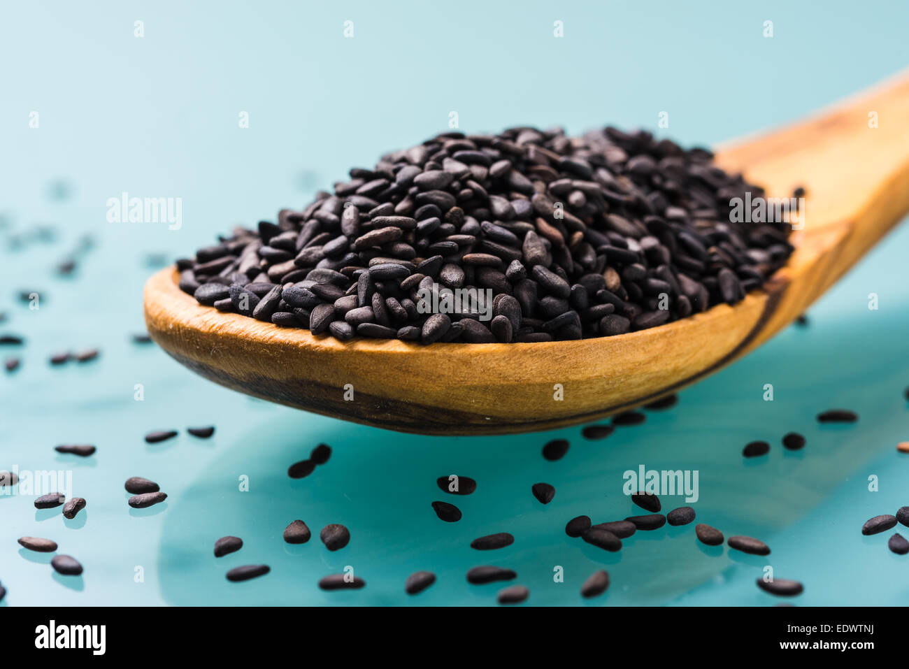 Graines de sésame noir sur une cuillère à olive en bois Banque D'Images
